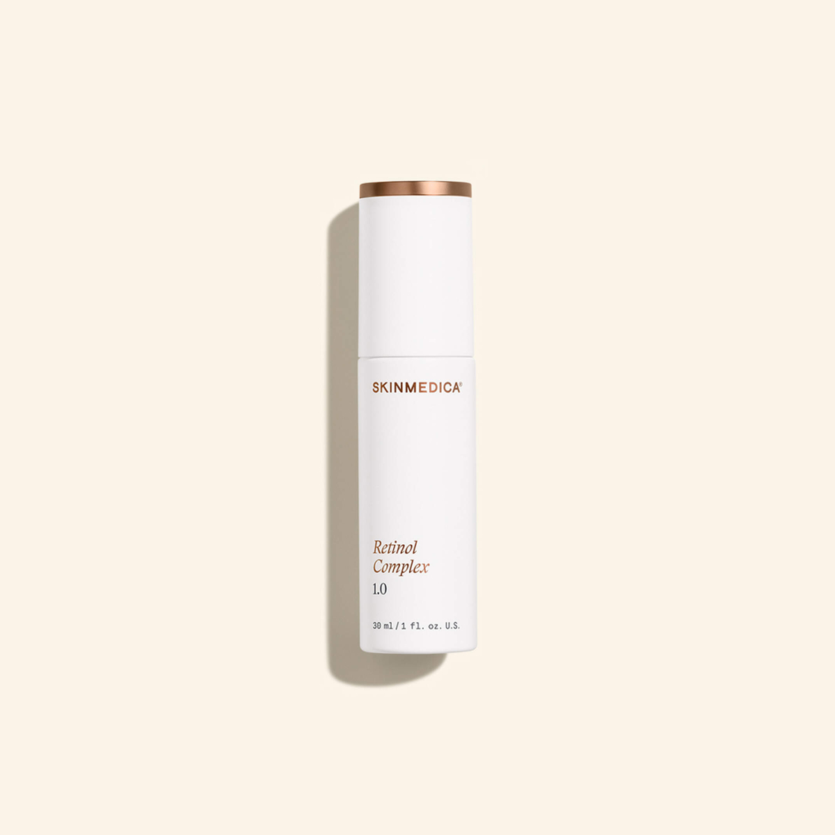 A white bottle of SkinMedica Retinol Complex 1.0, 30 ml size, with copper-colored accents, standing upright on a neutral background.